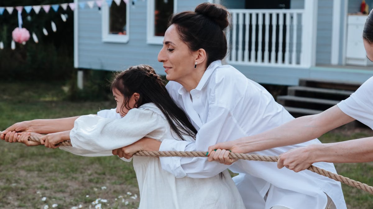 Family enjoying a playful tug of war game outdoors, showcasing teamwork and fun.